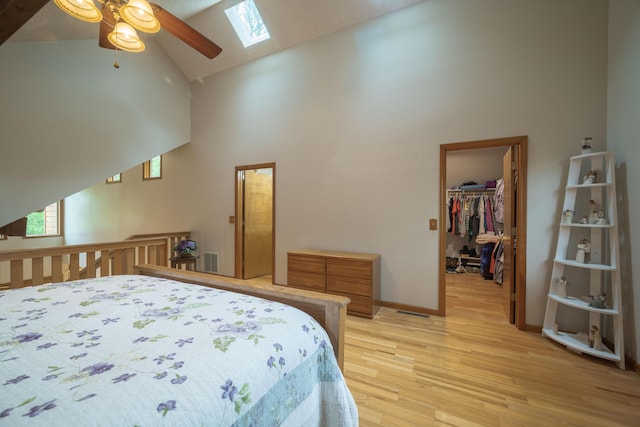 10703 Lawrence Unit 2230, Monett, MO 65708 - bedroom with high vaulted ceiling, a skylight, light wood-style floors, a walk in closet, and baseboards
