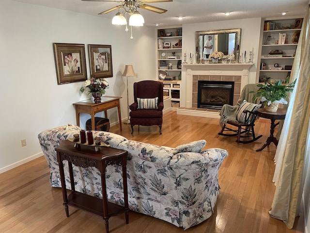 2704 Jennifer Dr, West Plains, MO 65775 - living room featuring wood finished floors, ceiling fan, a tiled fireplace, and baseboards