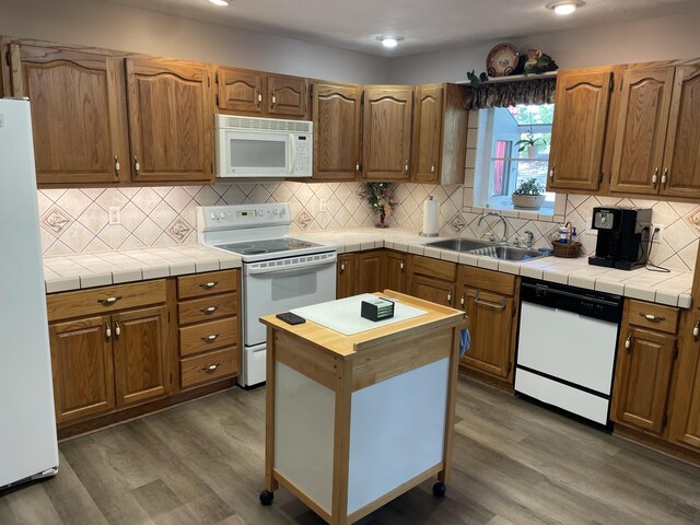 2704 Jennifer Dr, West Plains, MO 65775 - kitchen with white appliances, a sink, wood finished floors, and tasteful backsplash