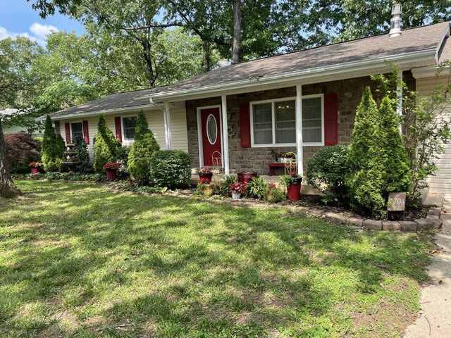 2704 Jennifer Dr, West Plains, MO 65775 - ranch-style house with a front lawn, covered porch, stone siding, and roof with shingles