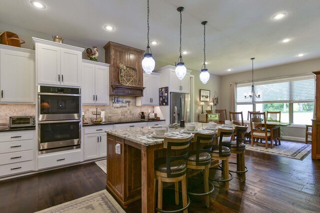 722 Seven Pines Dr, Saddlebrooke, MO 65630 - kitchen with appliances with stainless steel finishes, decorative backsplash, a center island with sink, dark wood-type flooring, and recessed lighting