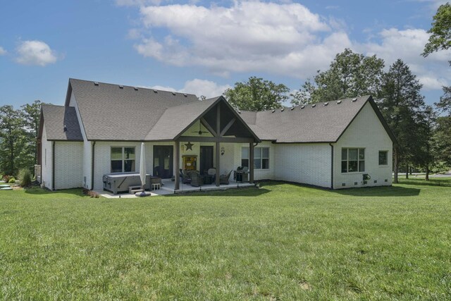722 Seven Pines Dr, Saddlebrooke, MO 65630 - rear view of property featuring a hot tub, a patio, a yard, roof with shingles, and brick siding