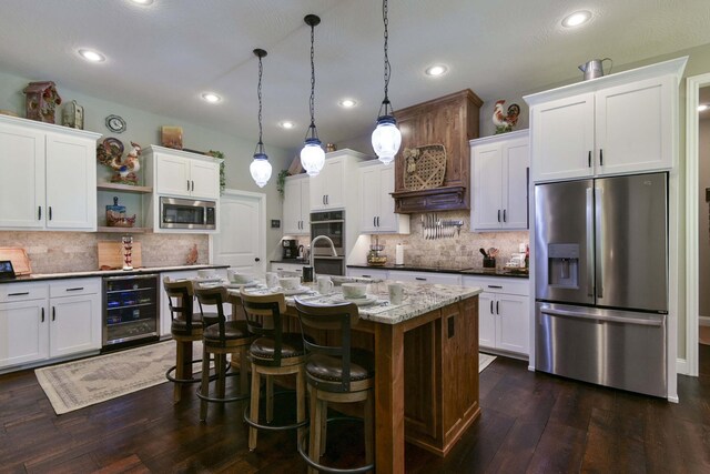 722 Seven Pines Dr, Saddlebrooke, MO 65630 - kitchen featuring appliances with stainless steel finishes, wine cooler, open shelves, tasteful backsplash, and dark wood-style floors