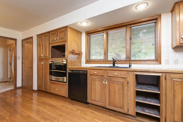 2117 E Wornall Pl, Springfield, MO 65804 - kitchen with dishwasher, stainless steel oven, light countertops, light wood-style flooring, and brown cabinets