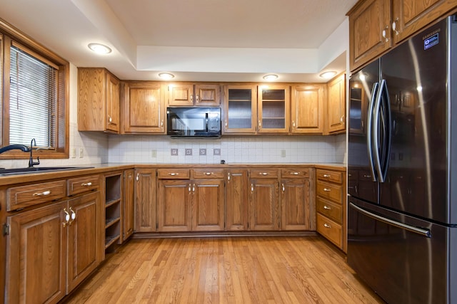 2117 E Wornall Pl, Springfield, MO 65804 - kitchen with stainless steel fridge, black microwave, brown cabinets, and light countertops