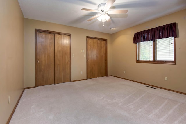 2117 E Wornall Pl, Springfield, MO 65804 - unfurnished bedroom with multiple closets, light colored carpet, and a ceiling fan