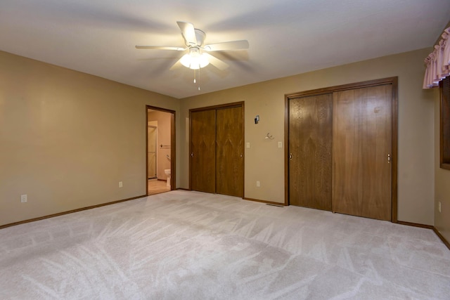 2117 E Wornall Pl, Springfield, MO 65804 - unfurnished bedroom featuring two closets, light carpet, ensuite bath, and a ceiling fan