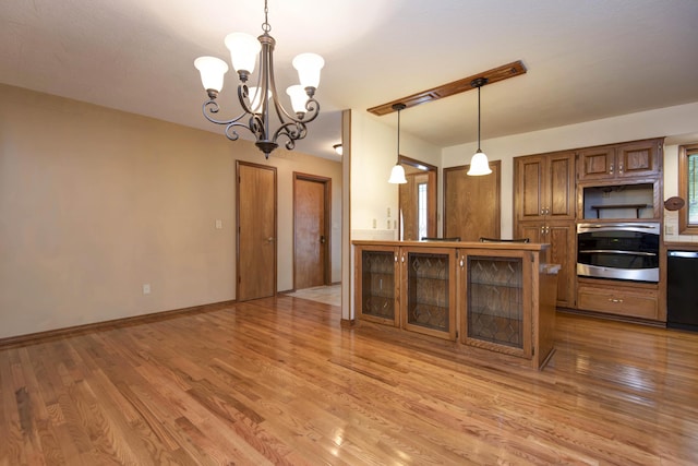 2117 E Wornall Pl, Springfield, MO 65804 - kitchen featuring stainless steel oven, brown cabinetry, a chandelier, and light wood-type flooring