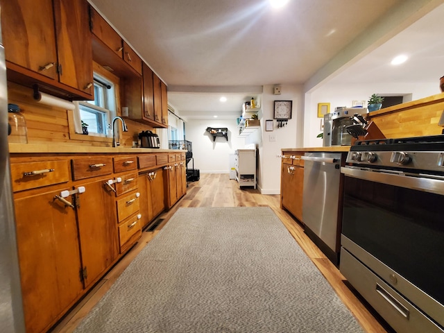 1010 Pine St, Cabool, MO 65689 - kitchen featuring stainless steel appliances, baseboards, light countertops, light wood-style flooring, and a sink