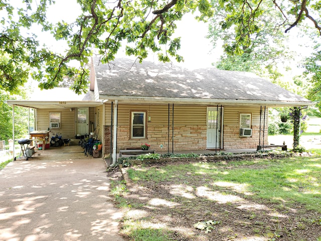 1010 Pine St, Cabool, MO 65689 - view of front of home featuring an attached carport, asphalt driveway, a porch, cooling unit, and a shingled roof