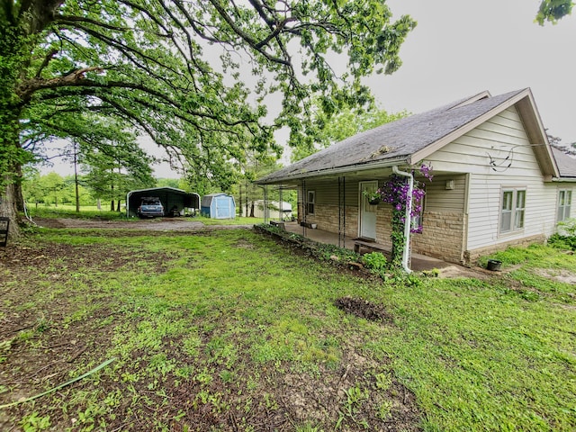 1010 Pine St, Cabool, MO 65689 - view of home's exterior featuring a carport, covered porch, roof with shingles, a lawn, and stone siding