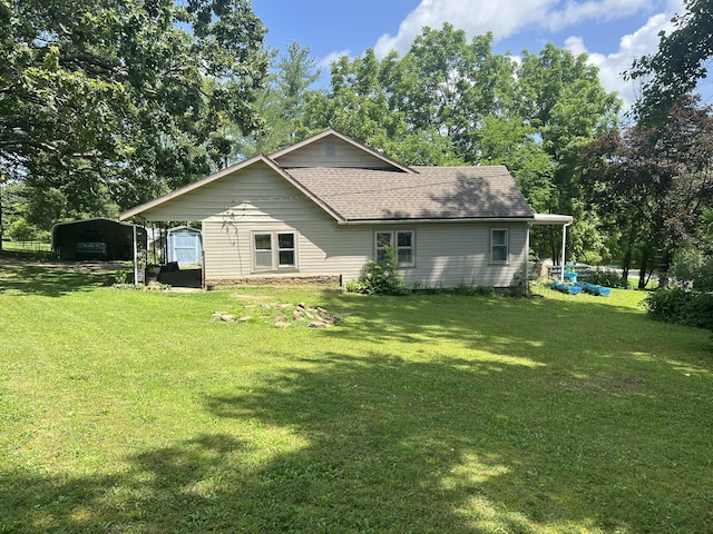 1010 Pine St, Cabool, MO 65689 - back of property with a carport, a lawn, a shingled roof, and view of scattered trees