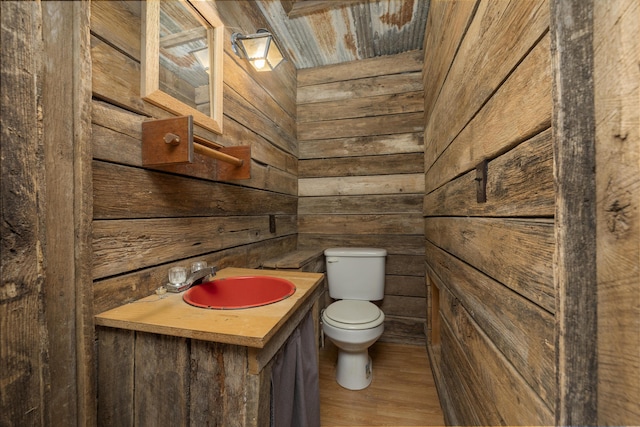 247 S Jefferson St, Walnut Grove, MO 65770 - half bathroom featuring wood walls, toilet, vanity, and wood finished floors