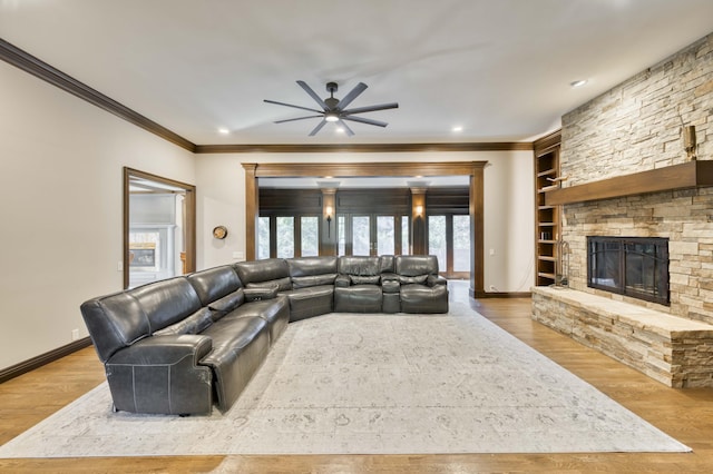 3596 E Montrose Ct, Springfield, MO 65809 - living room with a ceiling fan, wood finished floors, a stone fireplace, crown molding, and baseboards