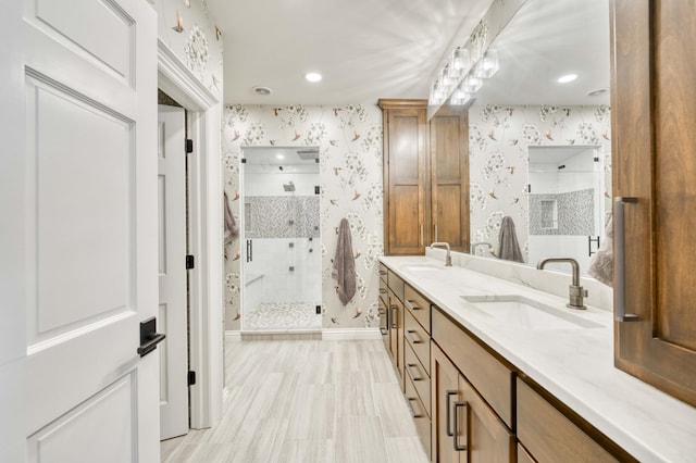 3596 E Montrose Ct, Springfield, MO 65809 - bathroom featuring wallpapered walls, a shower stall, double vanity, baseboards, and recessed lighting