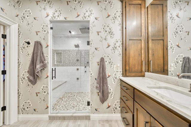 3596 E Montrose Ct, Springfield, MO 65809 - full bathroom with vanity, baseboards, a shower stall, wallpapered walls, and wood finished floors