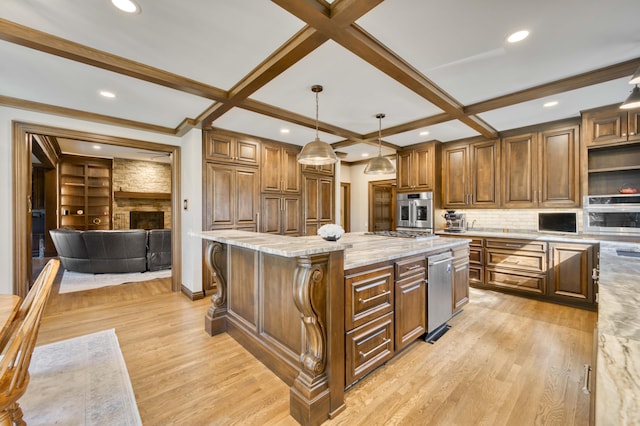 3596 E Montrose Ct, Springfield, MO 65809 - kitchen featuring appliances with stainless steel finishes, light wood-style flooring, backsplash, a kitchen island, and light stone countertops