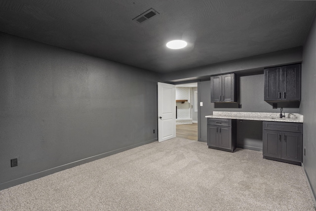 5715 S Clay Ave, Springfield, MO 65810 - kitchen featuring light carpet, baseboards, and a sink