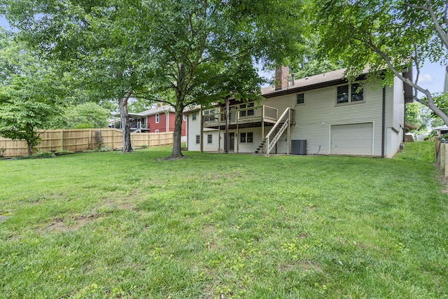 5715 S Clay Ave, Springfield, MO 65810 - back of house with a wooden deck, stairs, an attached garage, central air condition unit, and a chimney