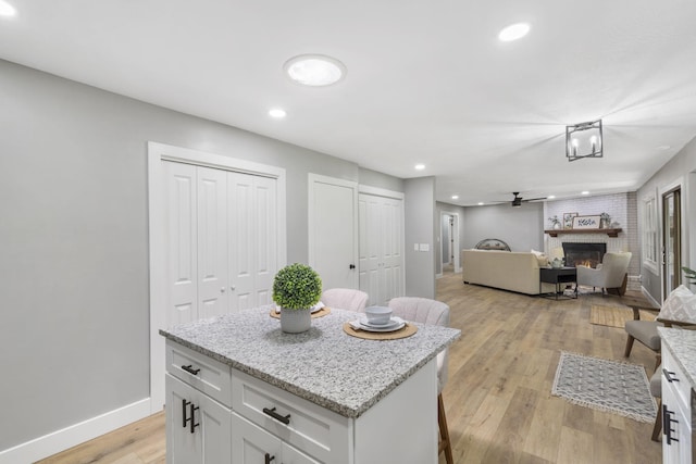5715 S Clay Ave, Springfield, MO 65810 - kitchen with a brick fireplace, open floor plan, white cabinetry, baseboards, and recessed lighting