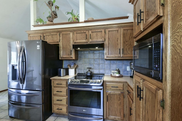 418 E Covington Rd, Willard, MO 65781 - kitchen featuring appliances with stainless steel finishes, under cabinet range hood, tasteful backsplash, and light tile patterned flooring