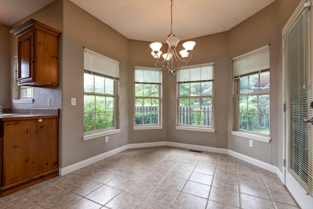 1214 Evington Ct, Springfield, MO 65803 - unfurnished dining area with a chandelier, light tile patterned floors, and baseboards