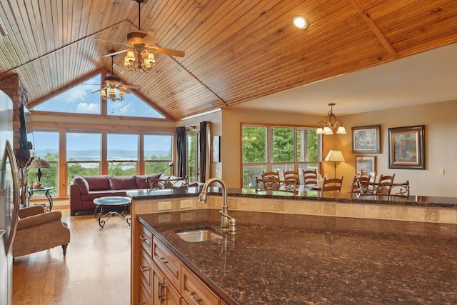 1041 Skyview Dr, Branson, MO 65616 - kitchen with a sink, open floor plan, a ceiling fan, wooden ceiling, and dark stone counters