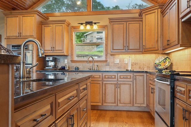 1041 Skyview Dr, Branson, MO 65616 - kitchen featuring stainless steel electric range oven, vaulted ceiling, wooden ceiling, brown cabinetry, and dark stone counters