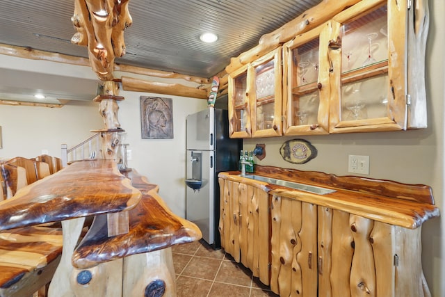 1041 Skyview Dr, Branson, MO 65616 - kitchen featuring dark tile patterned flooring, freestanding refrigerator, a sink, glass insert cabinets, and wood counters