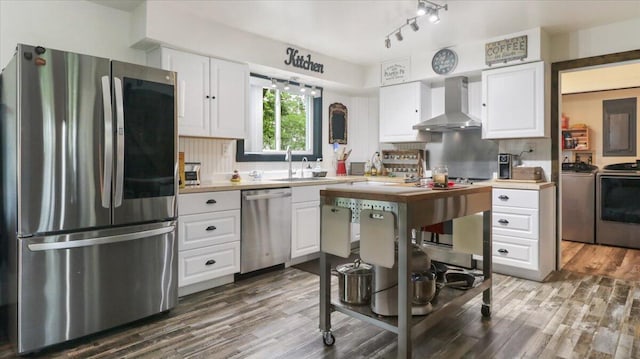 53 County Road 803a, Gainesville, MO 65655 - kitchen featuring stainless steel appliances, wall chimney exhaust hood, washer and clothes dryer, a sink, and wood finished floors