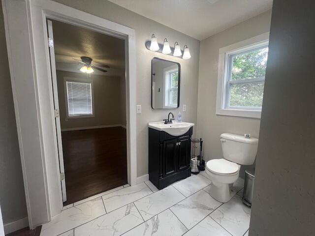 1217 Blair St, Cabool, MO 65689 - bathroom with vanity, marble finish flooring, toilet, a ceiling fan, and baseboards