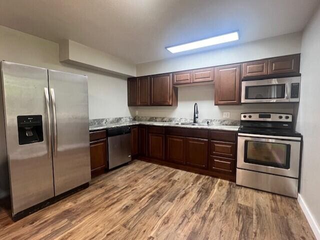 1217 Blair St, Cabool, MO 65689 - kitchen featuring stainless steel appliances, a sink, wood finished floors, and dark brown cabinets