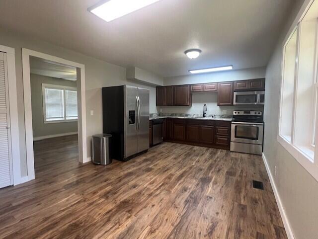1217 Blair St, Cabool, MO 65689 - kitchen with appliances with stainless steel finishes, a sink, baseboards, dark wood-style floors, and light countertops