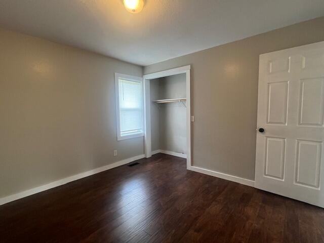 1217 Blair St, Cabool, MO 65689 - unfurnished bedroom featuring dark wood-type flooring, baseboards, and a closet