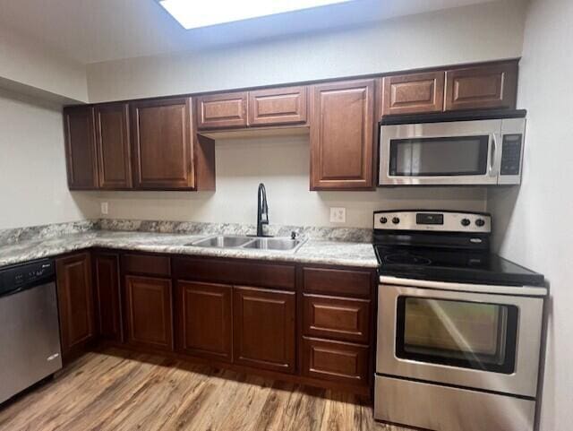 1217 Blair St, Cabool, MO 65689 - kitchen with stainless steel appliances, a sink, light countertops, and light wood finished floors