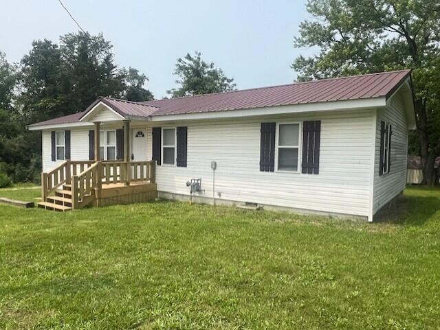 1217 Blair St, Cabool, MO 65689 - rear view of house featuring metal roof, a lawn, and covered porch