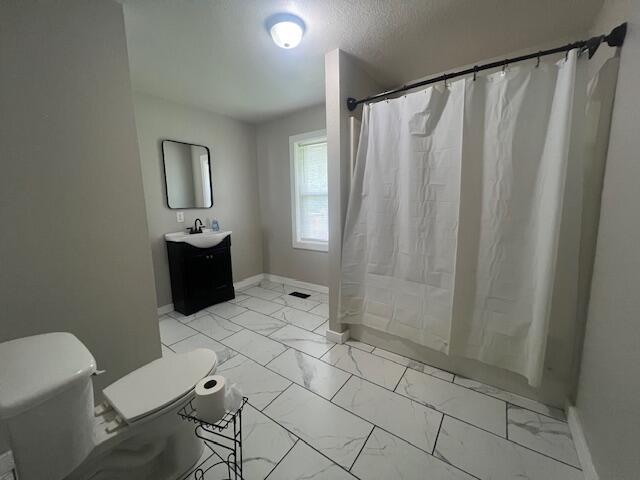 1217 Blair St, Cabool, MO 65689 - bathroom with marble finish flooring, toilet, vanity, and baseboards