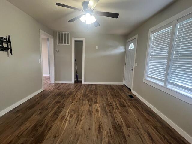 1217 Blair St, Cabool, MO 65689 - unfurnished living room with dark wood-type flooring, a ceiling fan, and baseboards