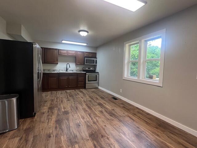 1217 Blair St, Cabool, MO 65689 - kitchen featuring stainless steel appliances, baseboards, light countertops, and dark wood-type flooring