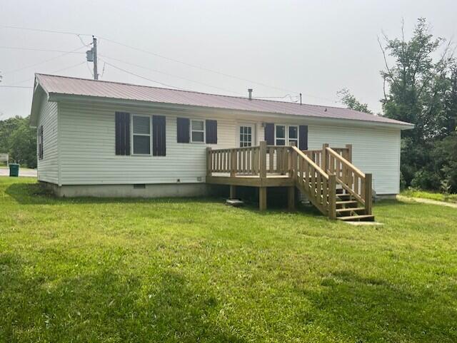 1217 Blair St, Cabool, MO 65689 - back of house featuring a wooden deck, crawl space, a lawn, and metal roof
