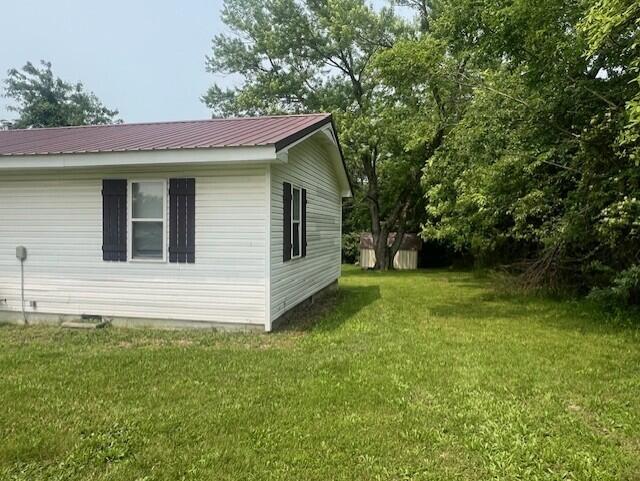 1217 Blair St, Cabool, MO 65689 - view of side of property featuring a lawn, metal roof, and crawl space