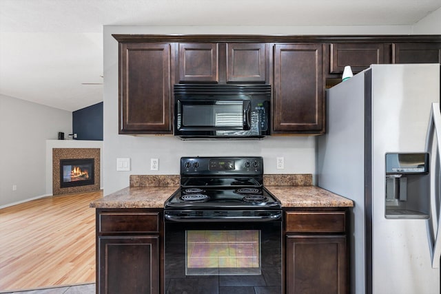 1311 Nitro Dr, Ozark, MO 65721 - kitchen with black appliances, dark brown cabinets, a glass covered fireplace, light wood finished floors, and lofted ceiling