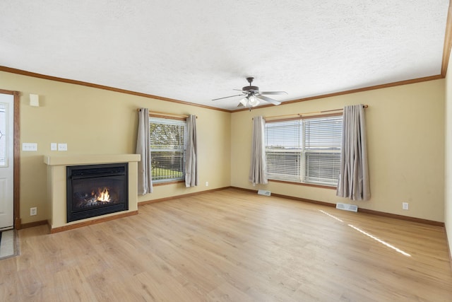 323 Shadrack Rd, Cape Fair, MO 65624 - unfurnished living room with light wood-type flooring, ceiling fan, a glass covered fireplace, ornamental molding, and a textured ceiling
