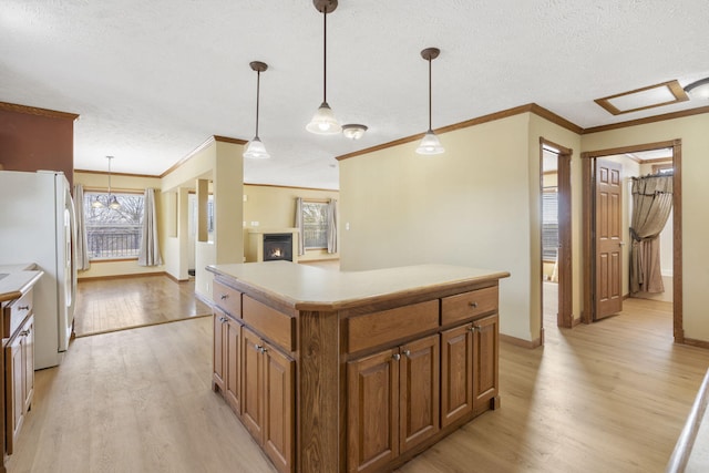 323 Shadrack Rd, Cape Fair, MO 65624 - kitchen with freestanding refrigerator, light wood-style floors, ornamental molding, brown cabinetry, and a textured ceiling