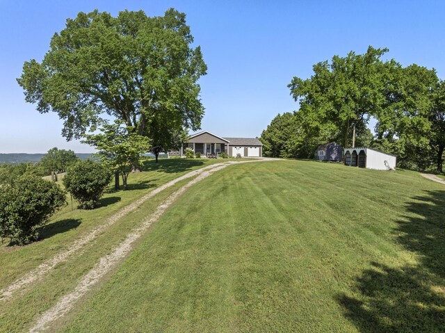 323 Shadrack Rd, Cape Fair, MO 65624 - view of green lawn featuring driveway, a garage, and an outbuilding