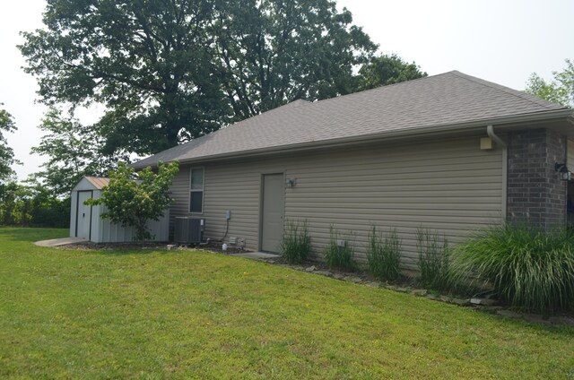 532 Holiday St, Highlandville, MO 65669 - view of side of property featuring central AC, a yard, roof with shingles, and brick siding