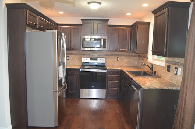 532 Holiday St, Highlandville, MO 65669 - kitchen with appliances with stainless steel finishes, a sink, dark wood-style flooring, dark brown cabinets, and decorative backsplash
