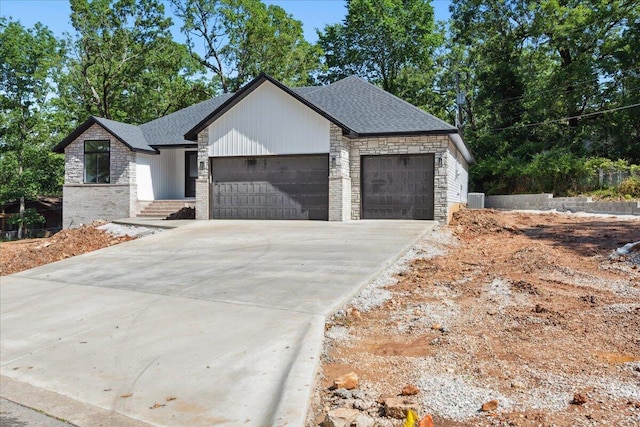 1239 W Arlington Ct, Springfield, MO 65803 - view of front of property with an attached garage, driveway, cooling unit, stone siding, and roof with shingles