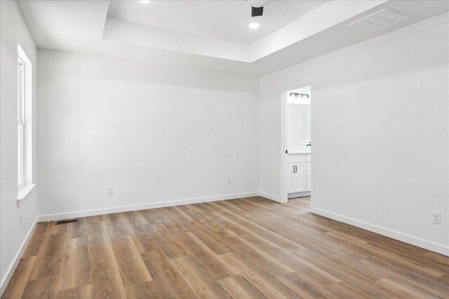 1239 W Arlington Ct, Springfield, MO 65803 - unfurnished room featuring a raised ceiling, light wood-style flooring, baseboards, and recessed lighting