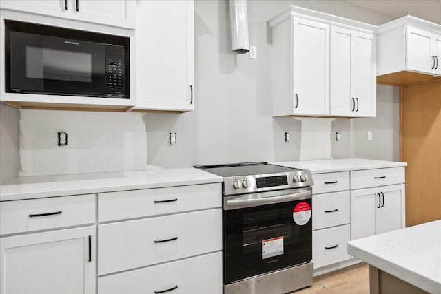 1239 W Arlington Ct, Springfield, MO 65803 - kitchen featuring black microwave, stainless steel electric range, light countertops, and white cabinets
